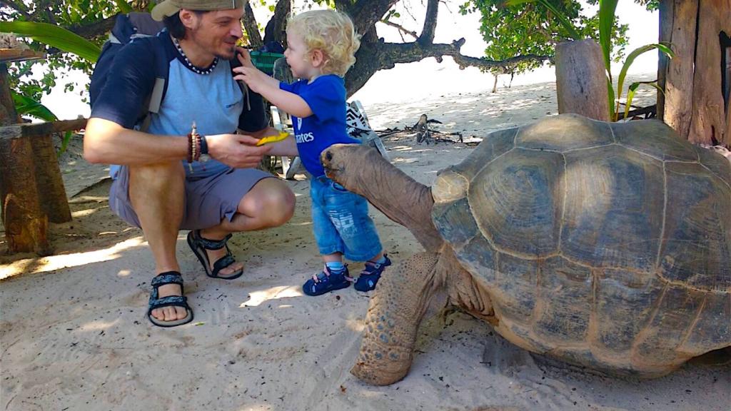 Padre e figlio con una tartaruga gigante di Aldabra